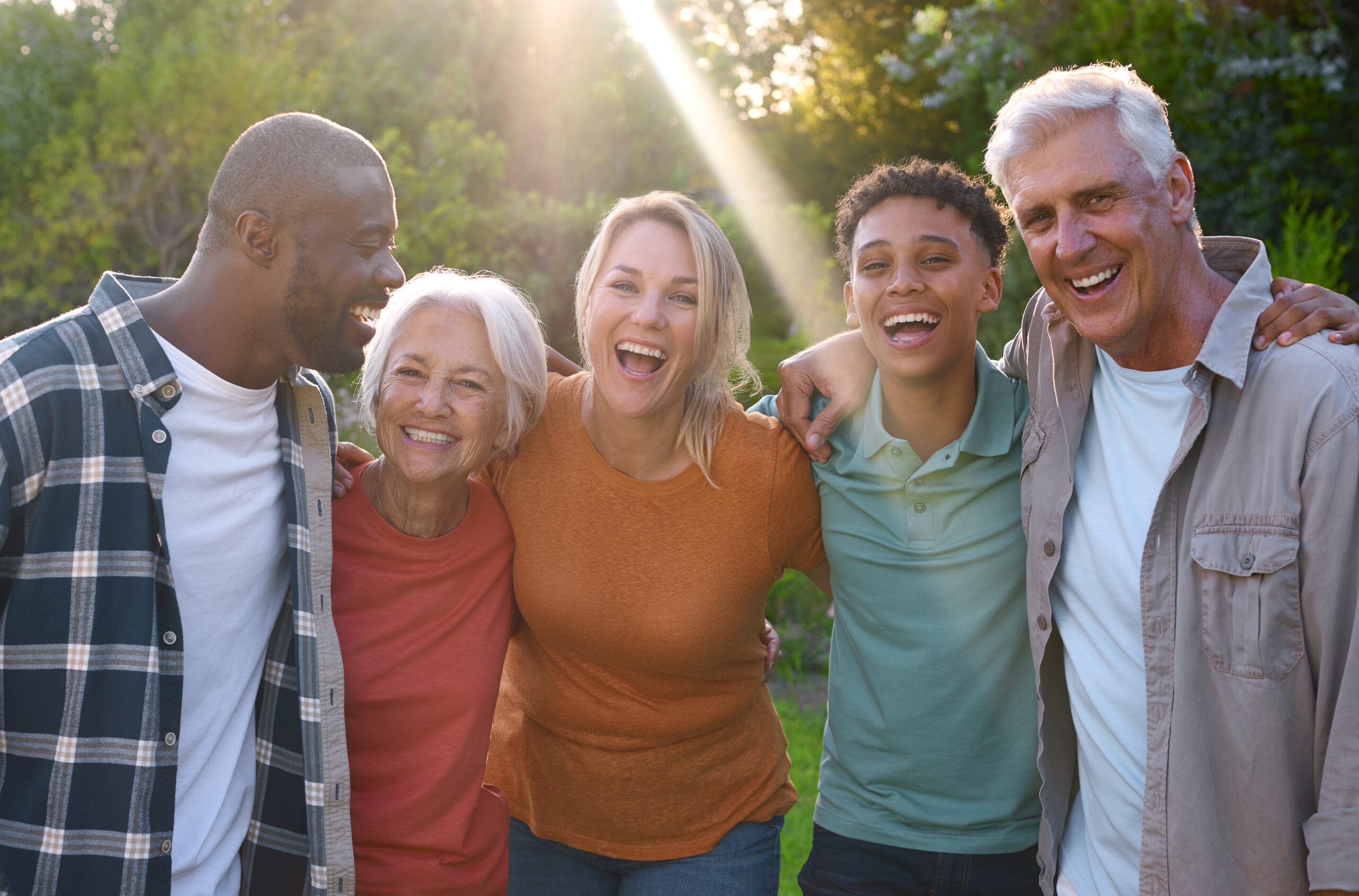 Portrait Of Three Generation Family Laughing And Smiling Sitting Outdoors On Walk In Countryside